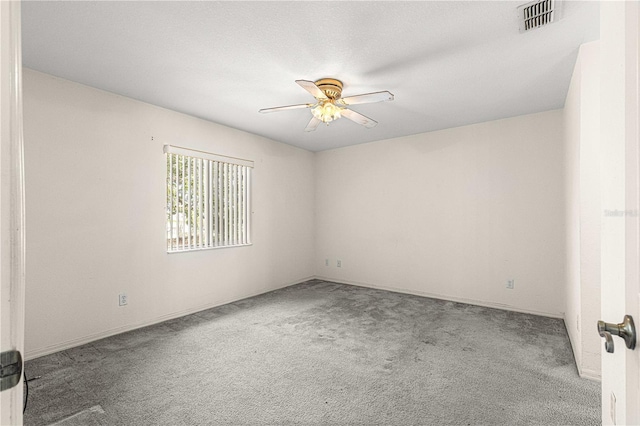 unfurnished room with carpet, visible vents, and a ceiling fan