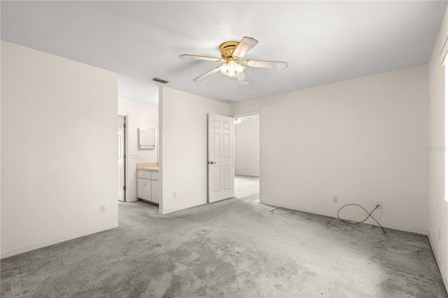 unfurnished bedroom featuring visible vents, a ceiling fan, light carpet, connected bathroom, and baseboards