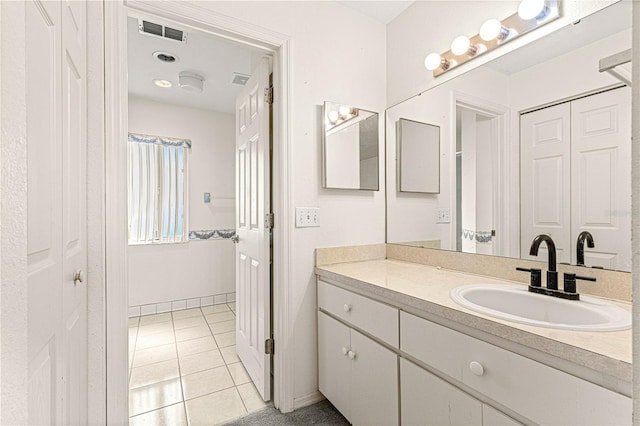 bathroom with baseboards, vanity, visible vents, and tile patterned floors