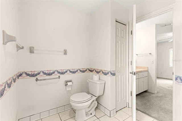 bathroom featuring visible vents, toilet, vanity, baseboards, and tile patterned floors