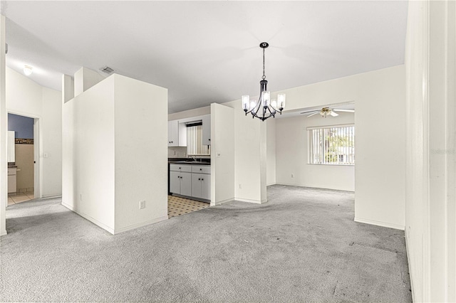 unfurnished living room with light colored carpet, ceiling fan with notable chandelier, a sink, visible vents, and baseboards