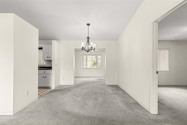 unfurnished dining area with a chandelier, carpet flooring, and baseboards