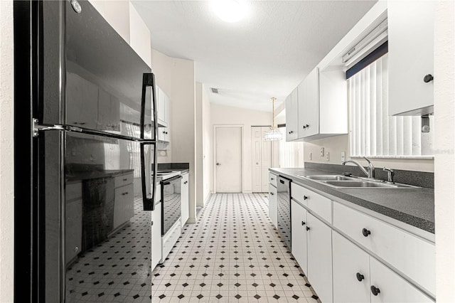 kitchen with a sink, white cabinetry, stainless steel dishwasher, and freestanding refrigerator