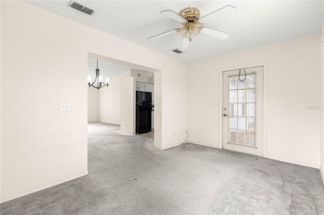 unfurnished room with light carpet, ceiling fan with notable chandelier, visible vents, and baseboards