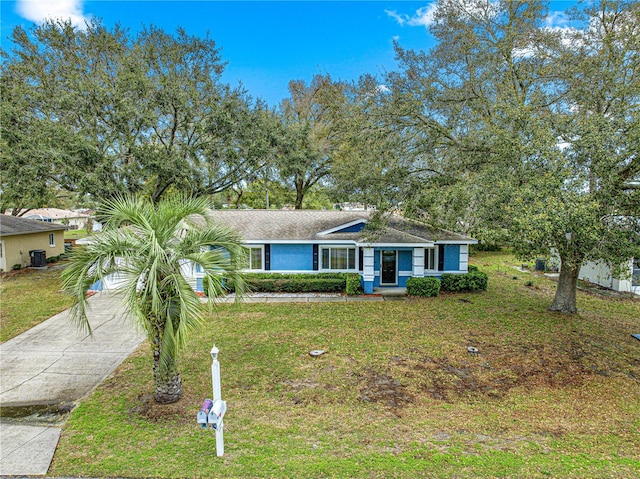 view of front of property featuring concrete driveway, a front yard, and stucco siding