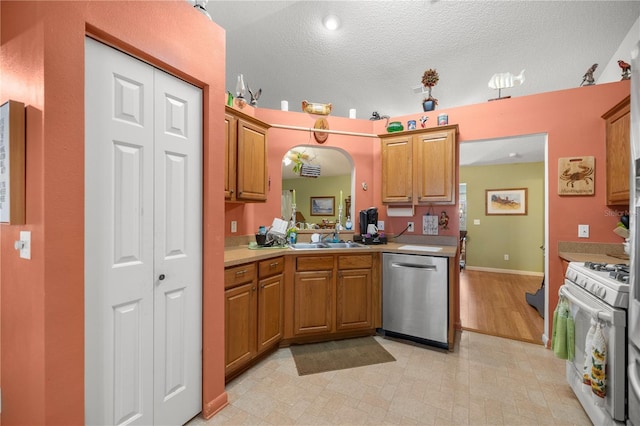 kitchen featuring a sink, light countertops, stainless steel dishwasher, white gas range oven, and brown cabinetry