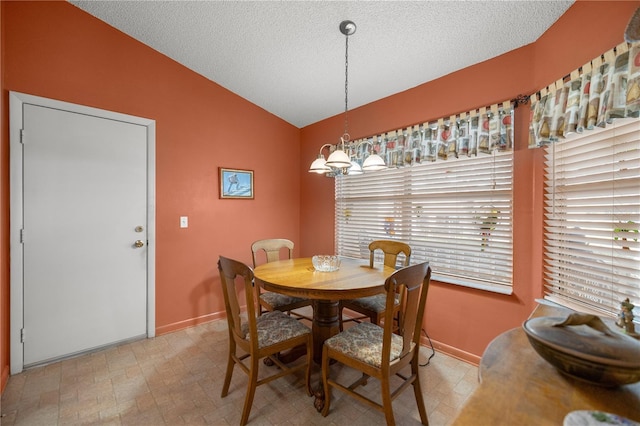 dining room featuring lofted ceiling, a textured ceiling, a chandelier, and baseboards