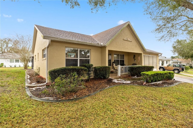 view of front facade featuring a garage, roof with shingles, a front lawn, and stucco siding