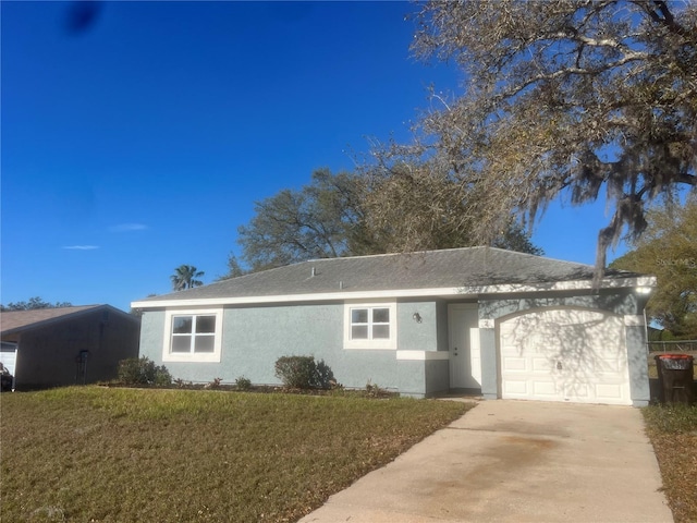 single story home featuring a garage, driveway, a front lawn, and stucco siding