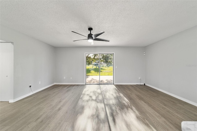 empty room featuring ceiling fan, wood finished floors, and baseboards