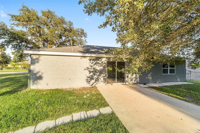 view of front of property with a front yard, fence, and stucco siding