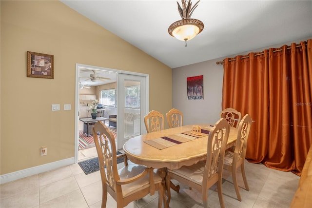 dining area with light tile patterned floors, baseboards, and vaulted ceiling