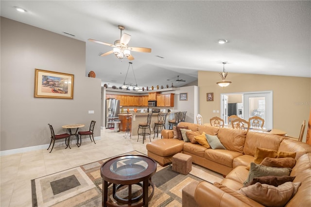 living room featuring a ceiling fan, vaulted ceiling, baseboards, and light tile patterned floors