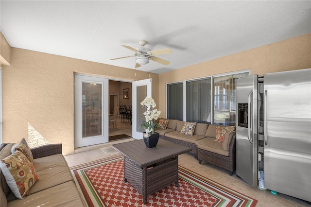 exterior space featuring light tile patterned floors, ceiling fan, and a textured wall