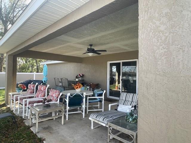 view of patio with fence and a ceiling fan