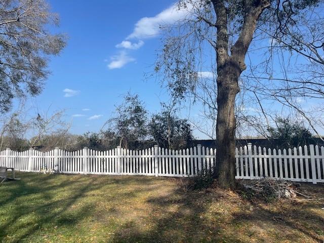 view of gate with fence and a yard