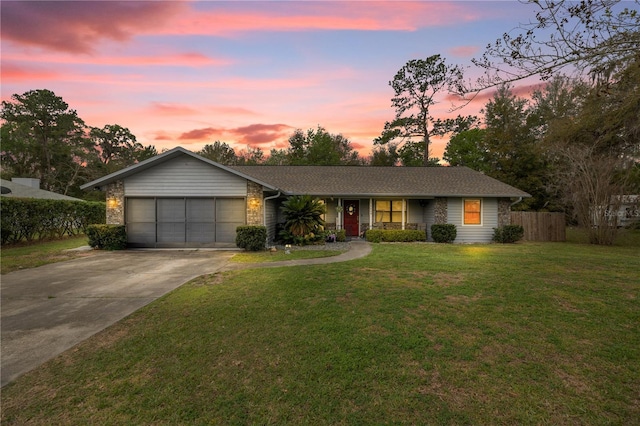 ranch-style house featuring concrete driveway, a lawn, an attached garage, and fence