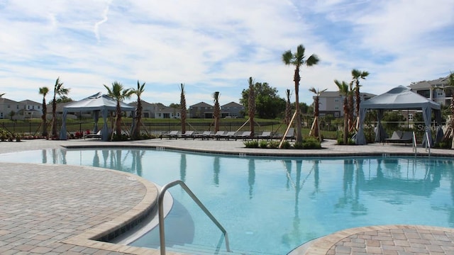 pool with a gazebo, a patio, and fence