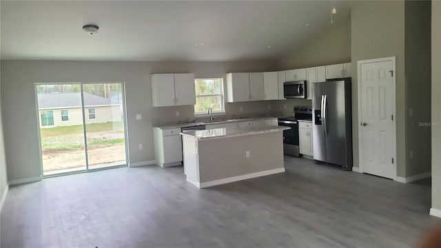 kitchen featuring a kitchen island, a sink, white cabinets, light countertops, and appliances with stainless steel finishes