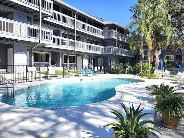 pool with a patio and fence