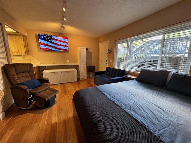 bedroom featuring a textured ceiling and wood finished floors