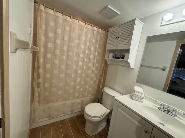 full bath featuring a textured wall, toilet, wood tiled floor, shower / tub combo, and vanity