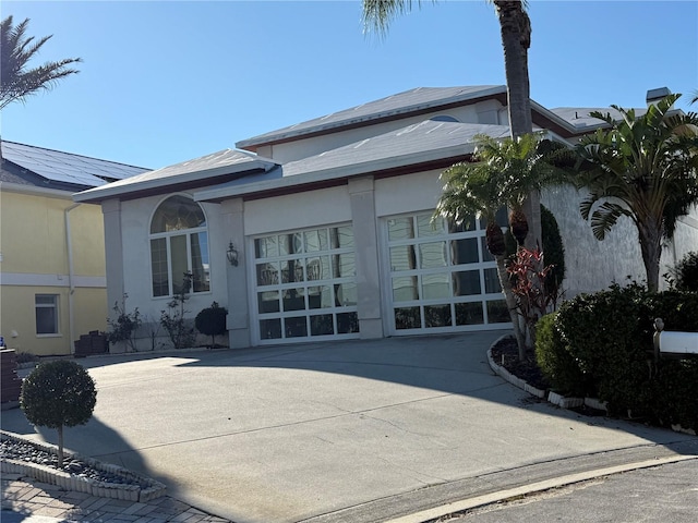 exterior space with driveway, an attached garage, and stucco siding