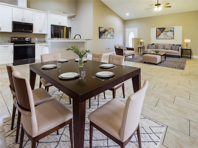 dining area featuring a ceiling fan and high vaulted ceiling