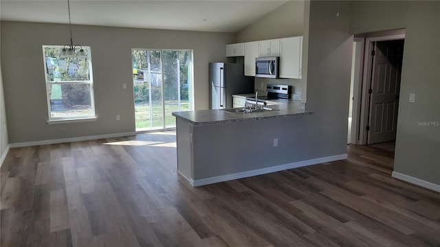 kitchen featuring dark wood-style flooring, stainless steel appliances, white cabinetry, a sink, and baseboards