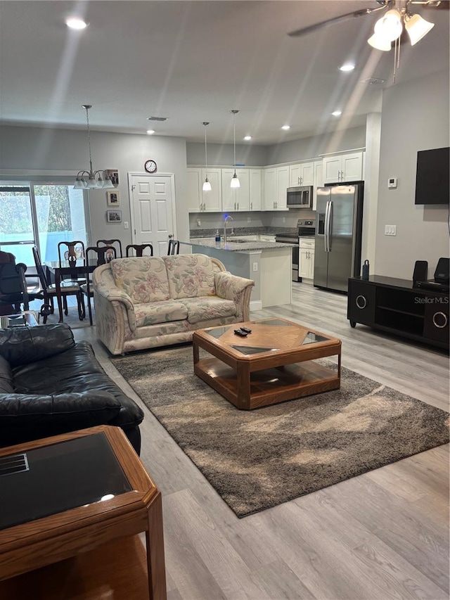 living room featuring ceiling fan, light wood finished floors, visible vents, and recessed lighting