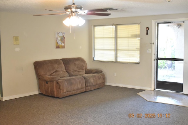 living area with a wealth of natural light, visible vents, baseboards, and carpet flooring