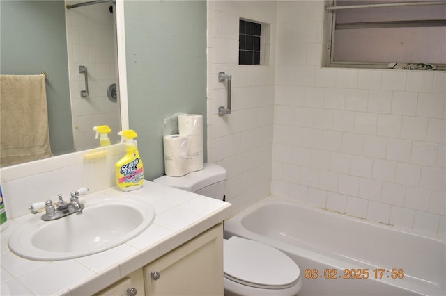 bathroom featuring toilet, vanity, and shower / bathing tub combination