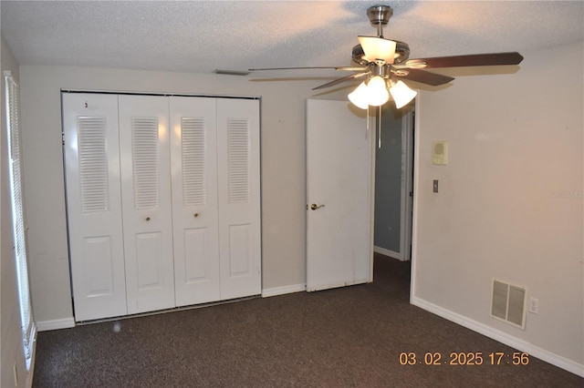 unfurnished bedroom featuring baseboards, visible vents, a closet, a textured ceiling, and dark colored carpet