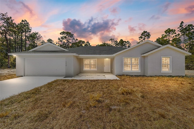 ranch-style house with stucco siding, a front lawn, concrete driveway, and an attached garage