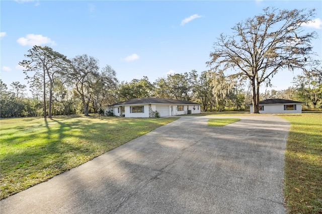 view of front of property featuring a front lawn, an attached garage, and driveway