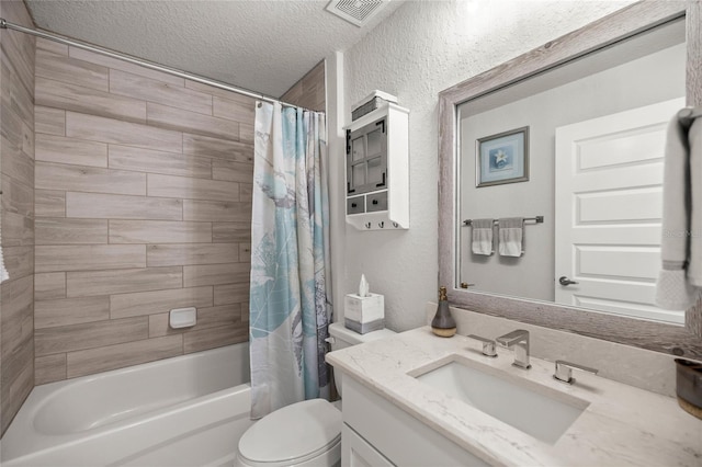 full bathroom featuring visible vents, toilet, vanity, shower / bath combination with curtain, and a textured ceiling