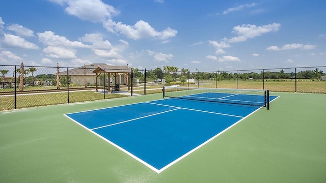 view of tennis court featuring fence