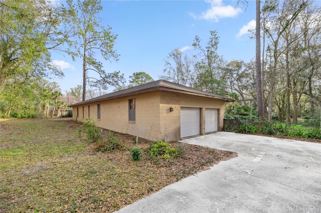 view of home's exterior featuring concrete block siding and a detached garage