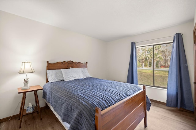 bedroom with light wood-style floors and baseboards