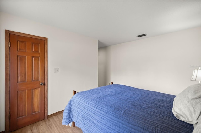 bedroom with light wood-type flooring, visible vents, and baseboards