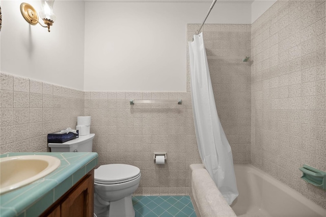 full bathroom featuring toilet, a wainscoted wall, shower / tub combo with curtain, vanity, and tile walls