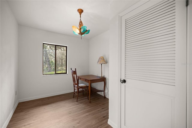 office with light wood-style floors, baseboards, and a chandelier