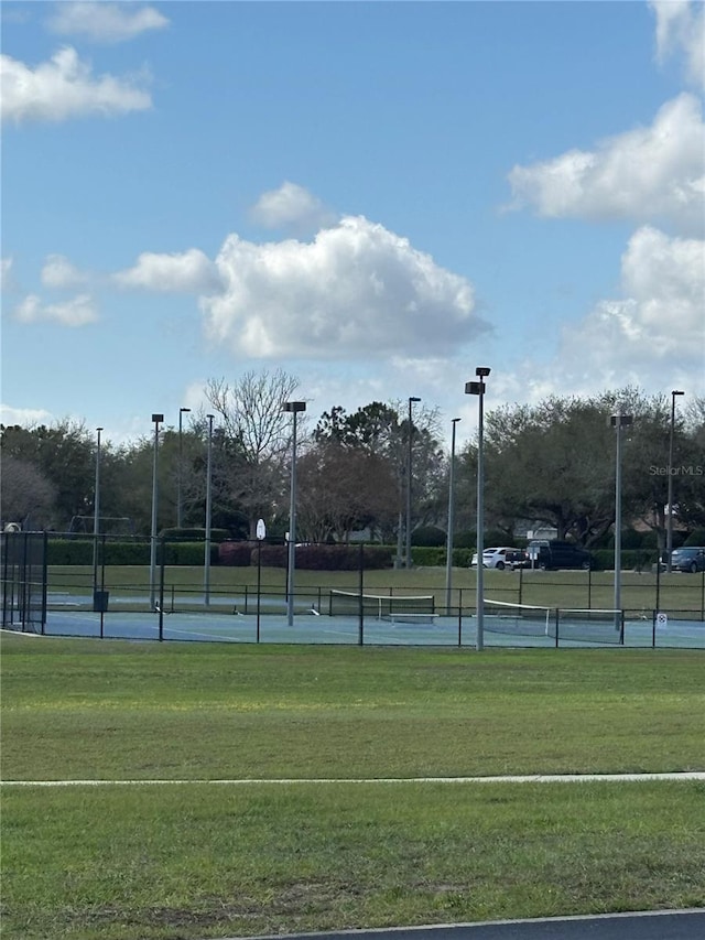 view of sport court with a yard and fence