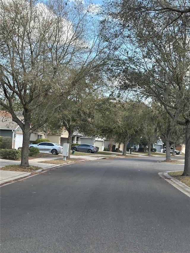 view of road with curbs, a residential view, and sidewalks