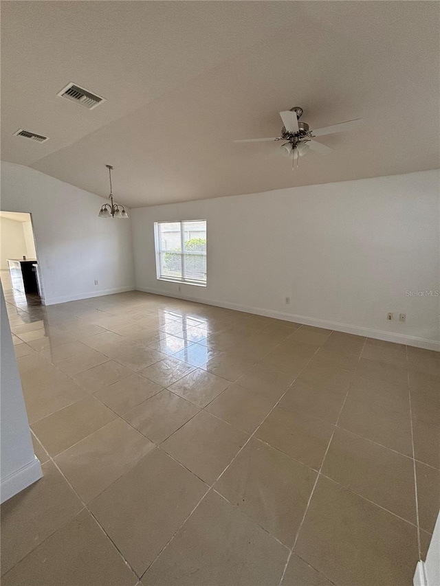 spare room with light tile patterned floors, visible vents, ceiling fan with notable chandelier, and baseboards