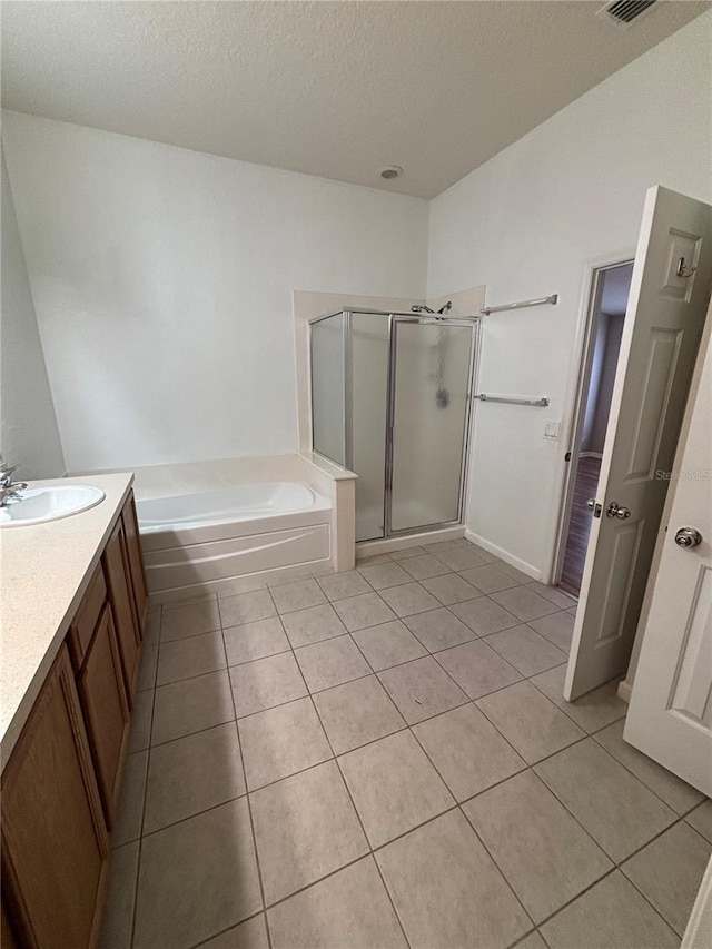 full bath featuring vanity, a stall shower, tile patterned flooring, a textured ceiling, and a bath