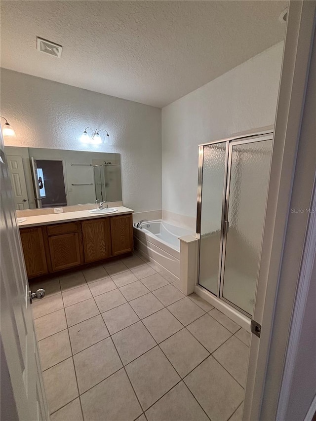 full bath with visible vents, a shower stall, a garden tub, a textured wall, and tile patterned floors