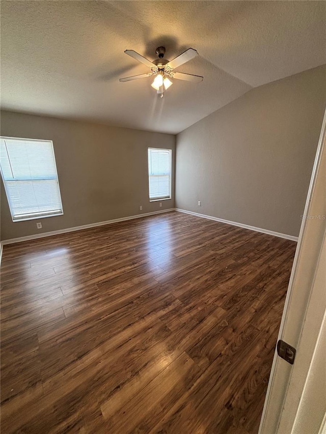 unfurnished room with baseboards, a textured ceiling, dark wood finished floors, and a ceiling fan