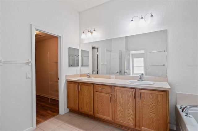 4954 SW 40th Pl, Ocala, FL 34474 - bathroom featuring double vanity, tile patterned flooring, a bath, and a textured wall