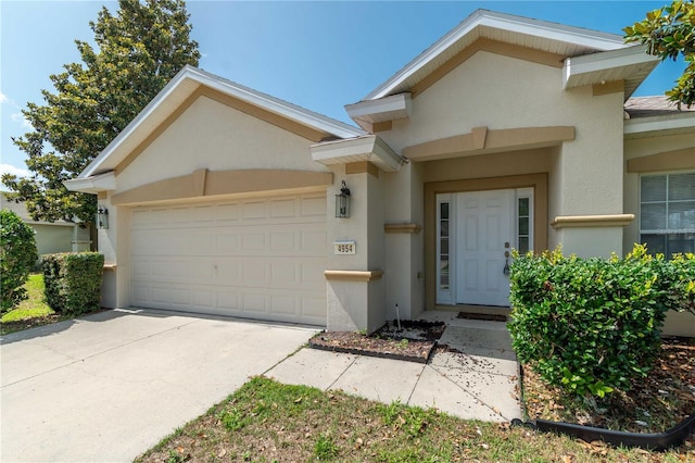 4954 SW 40th Pl, Ocala, FL 34474 - view of front of home with stucco siding, an attached garage, and concrete driveway